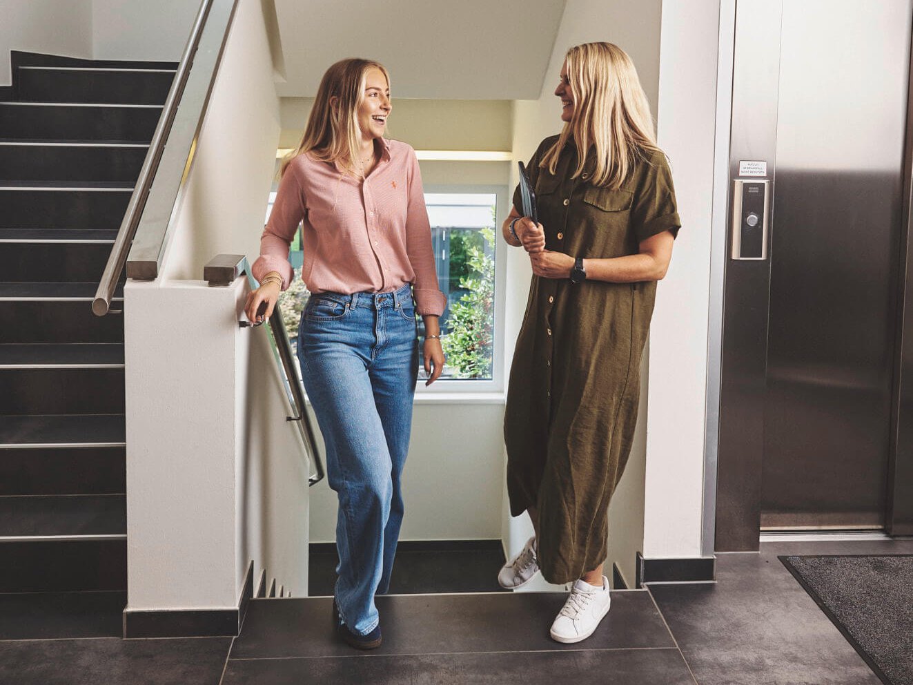 Zwei Frauen besprechen sich auf dem Weg zum Meetingraum.