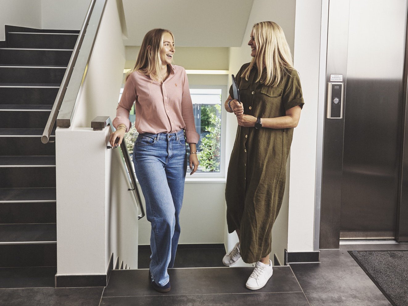 Zwei Frauen besprechen sich auf dem Weg ins Meeting.